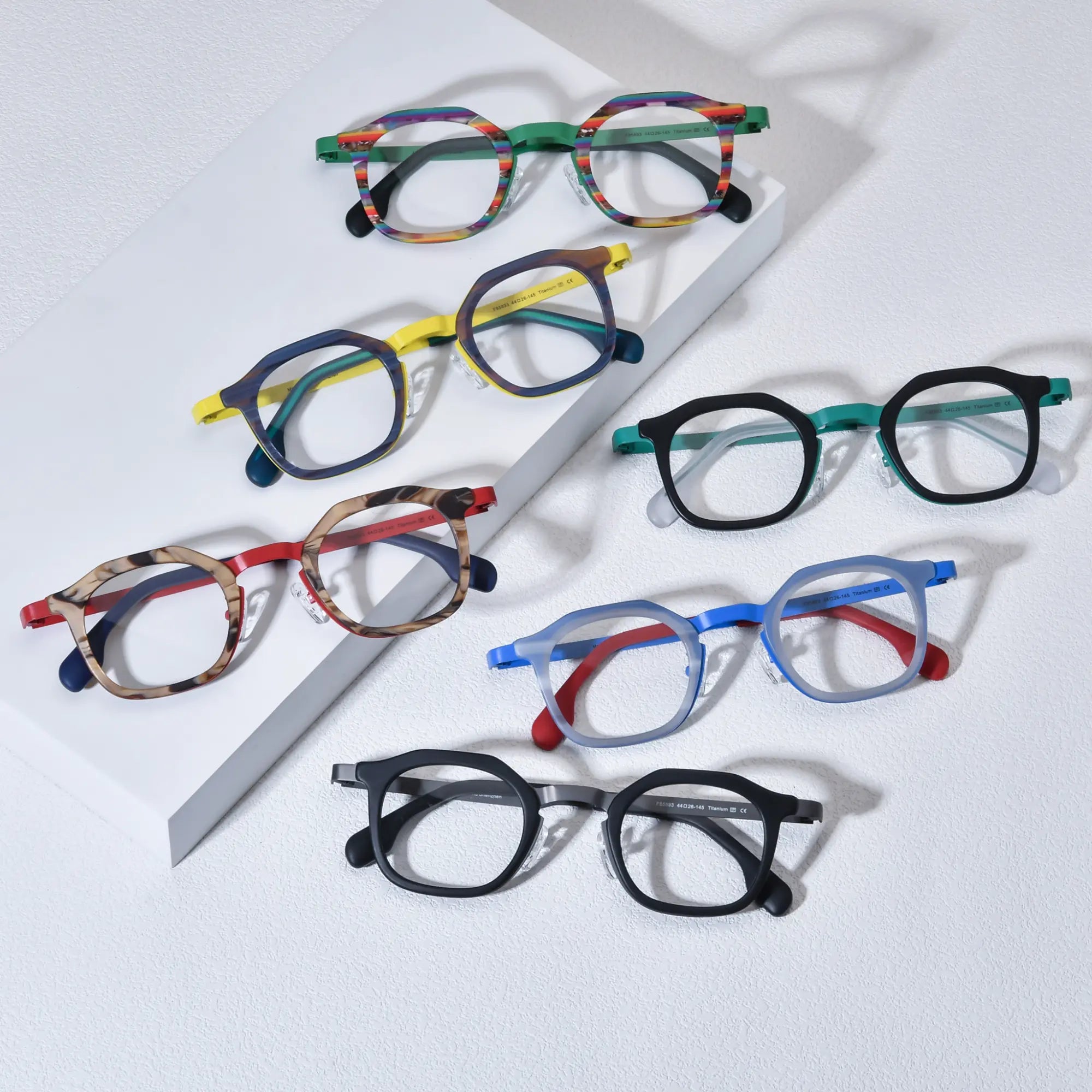 Group overview of VoyueLens™ VL185893 geometric square eyeglasses in all six color variants: Aurora Stripe, Citrus Noir, Ocean Signal, Forest Frost, Graphite Mist, and Crimson Drift. Showcasing color-block acetate fronts and titanium temples on a white background.